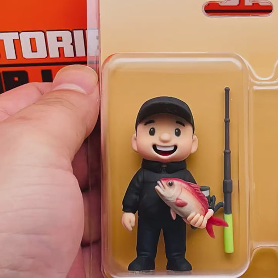 Video showcasing a custom-made 3D figurine of a fisherman with his catch, in its clear retail packaging for personalized gifts.
